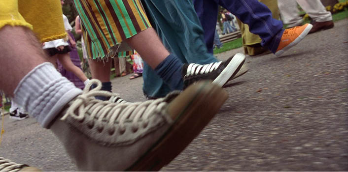 A group of people walking on a sidewalk. Description generated by AI