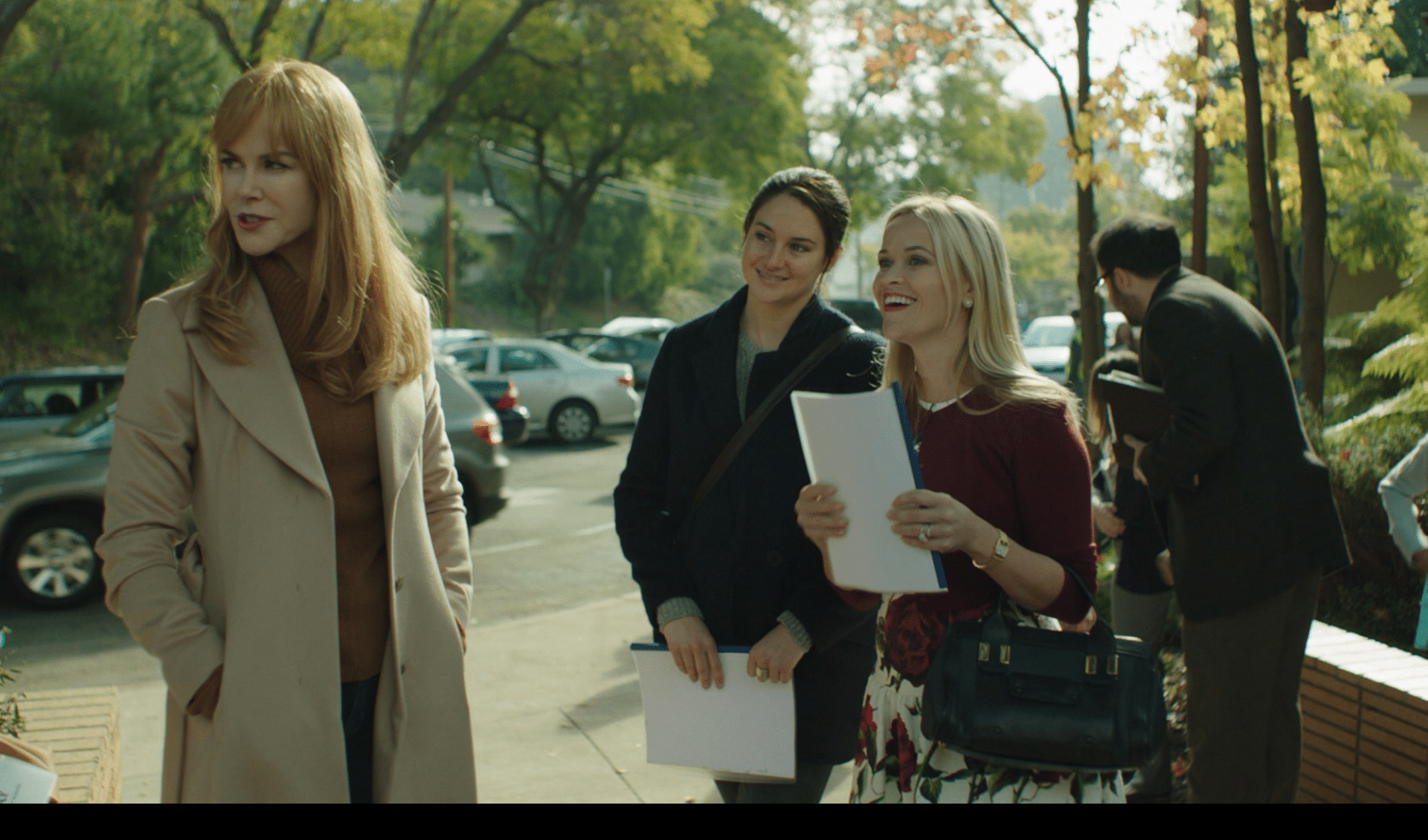 Three women standing on the sidewalk. Description generated by AI