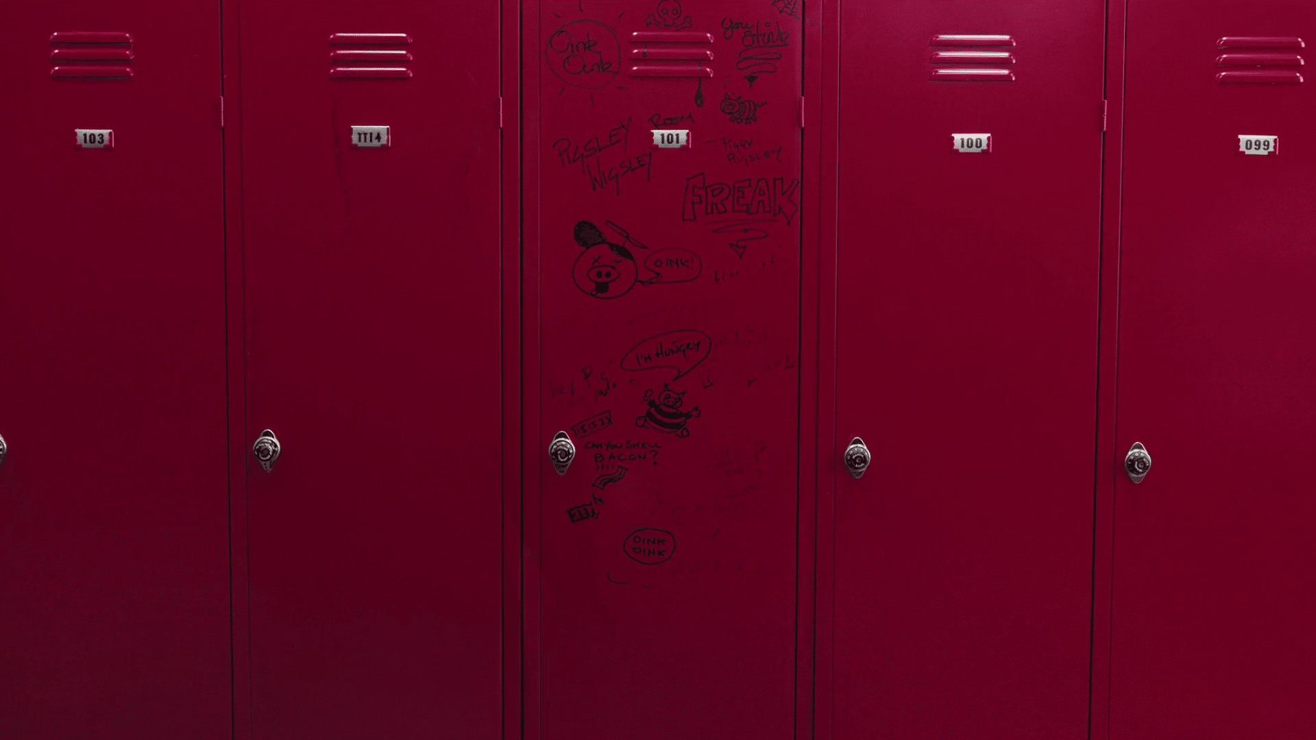 A red locker room with graffiti on the doors. Description generated by AI
