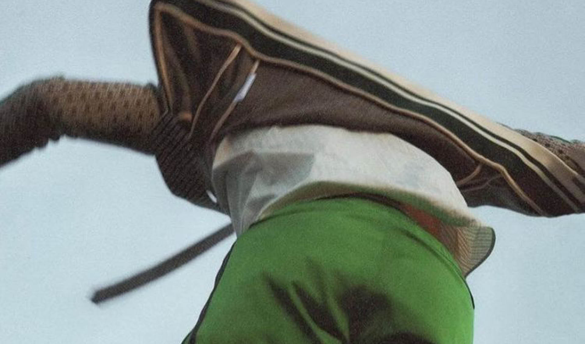 A person wearing a green skirt and white shirt. Description generated by AI