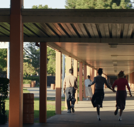 A group of people walking under a covered walkway. Description generated by AI